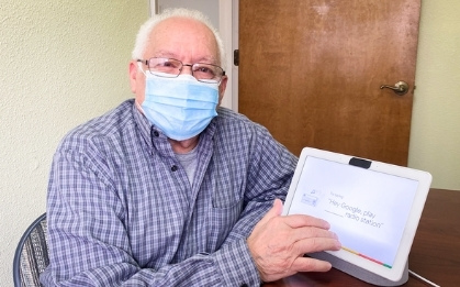 Elderly man in surgical mask interacting with tablet