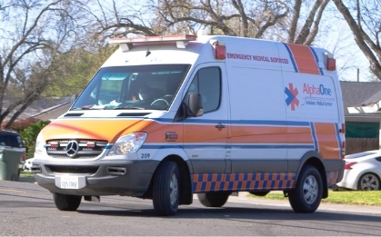 Orange and white ambulance on a sunny street