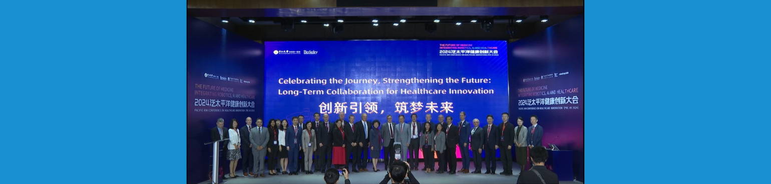 A group of people standing on a stage in front of a screen that says Celebrating the Journey, Strengthening the Future: Longterm collaboration for Healthcare Innovation