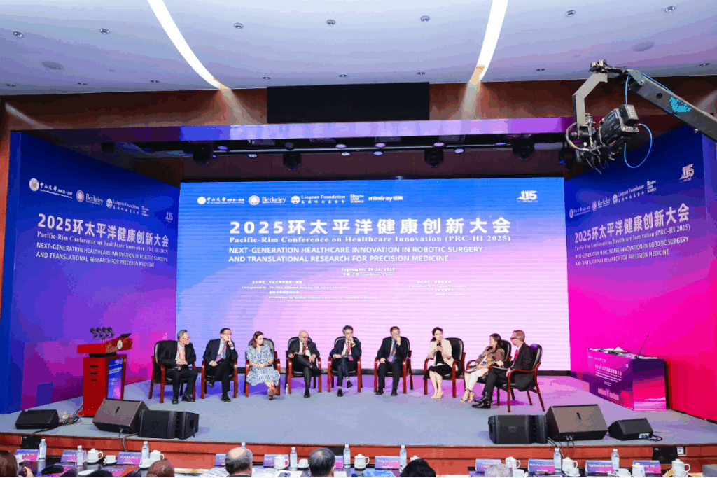 9 people seated for a discussion on a stage