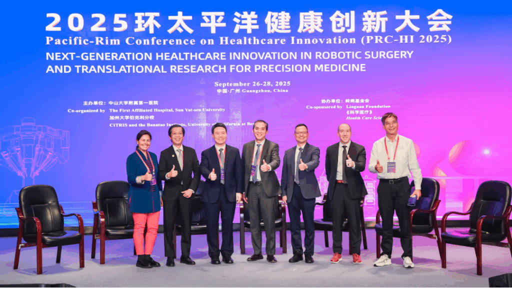 a group of people posing with thumbs up, behind them is a sign with "Next-generation healthcare innovation in robotic surgery and translational research for precision medicine"